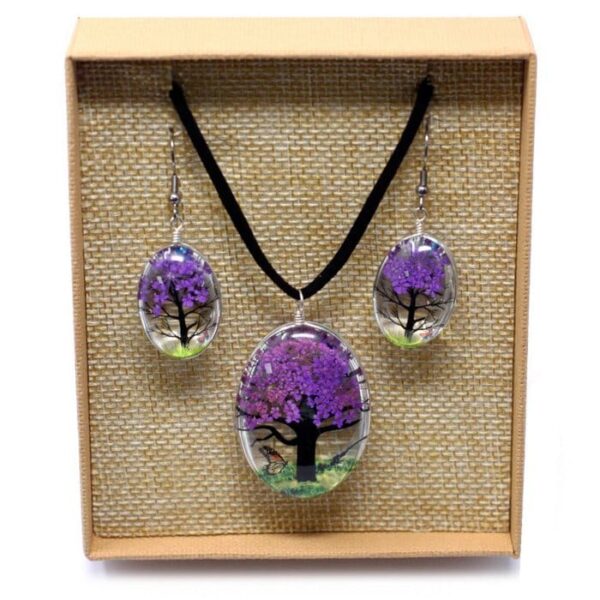 Een Tree of Life sieradenset in lavendel, met ketting en oorbellen van glas en gedroogde takjes, gepresenteerd in een beige doosje