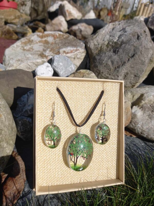 Een groene Tree of Life sieradenset (ketting en oorbellen) met glas en gedroogde bloemen, gepresenteerd in een doosje